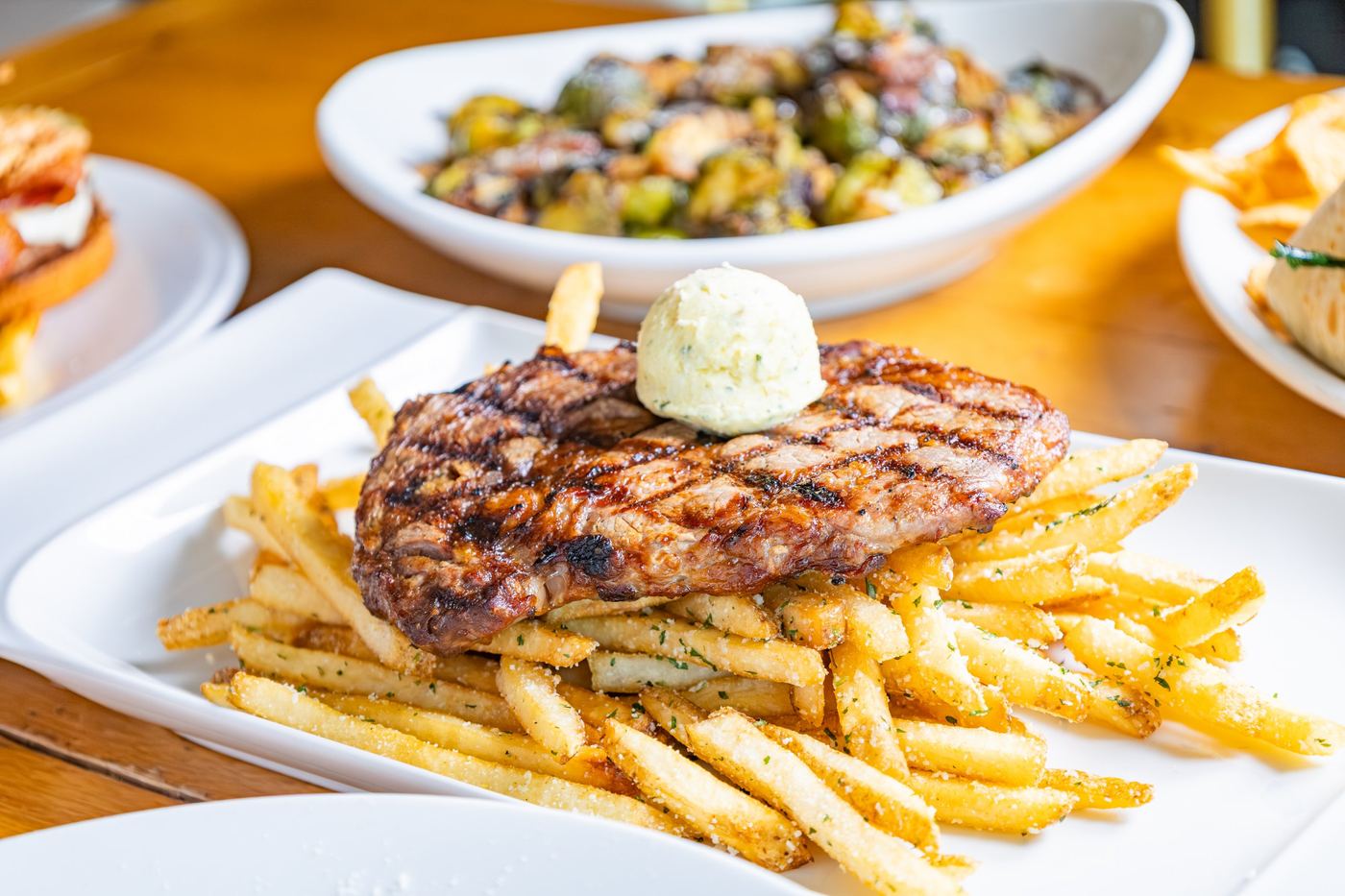 Grilled steak with herb butter over fries