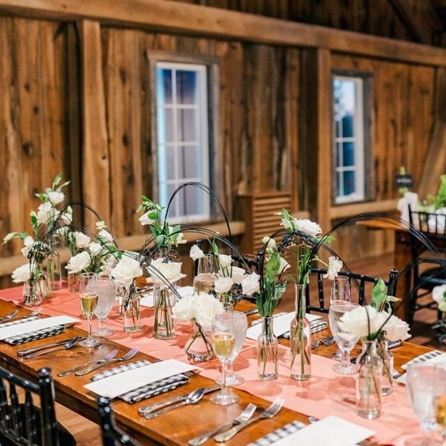 A long farm table set with white flowers