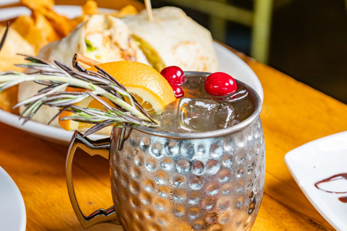 A mule cocktail with rosemary, orange and cranberries